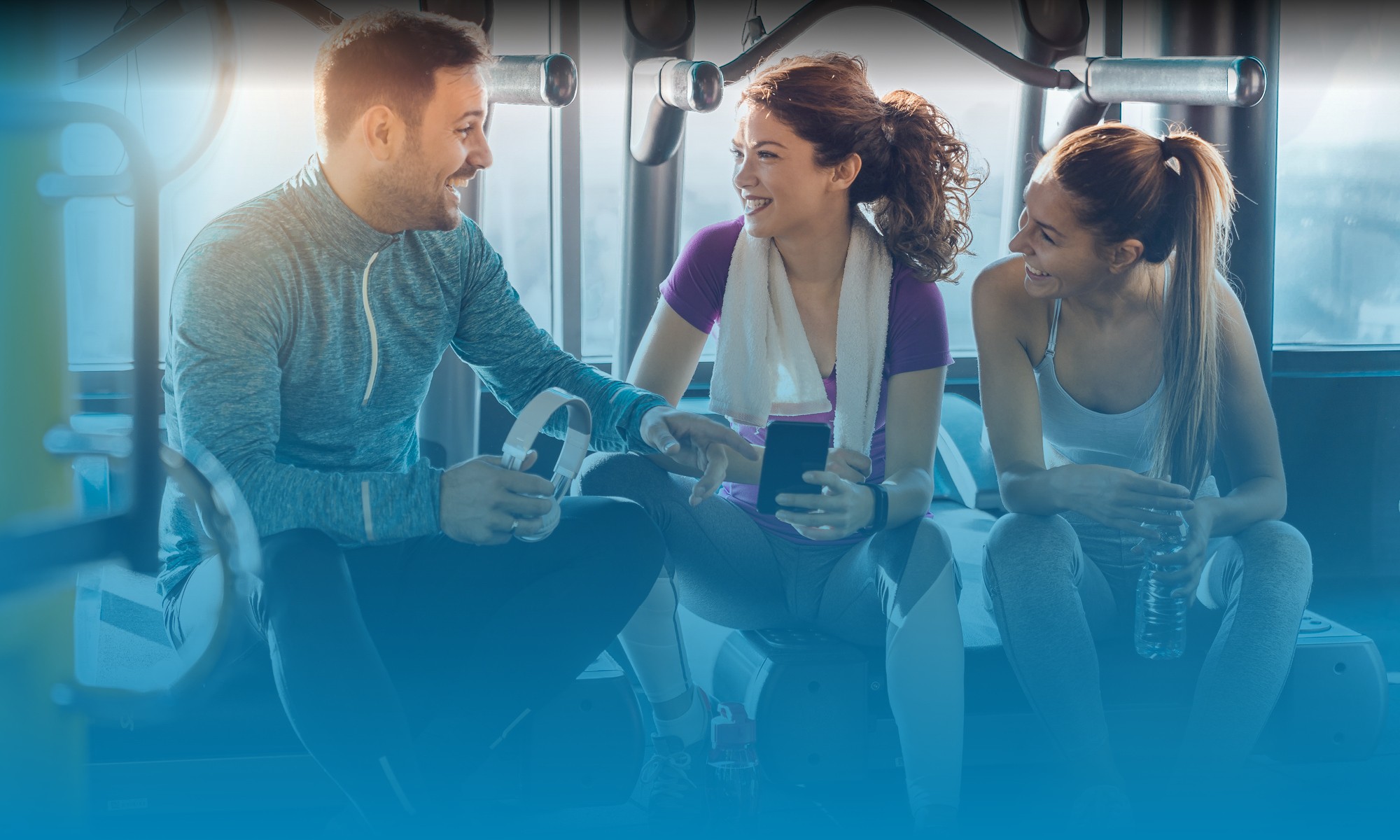 Three people having a conversation at a gym in Greenwood Village, CO