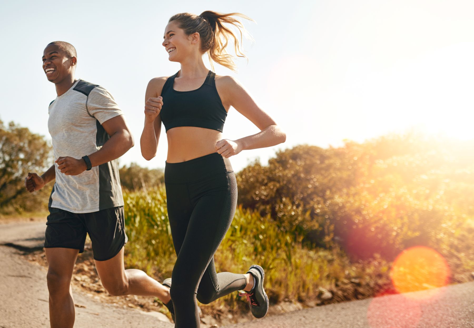 A lady smiling and running in workout clothes and shoes