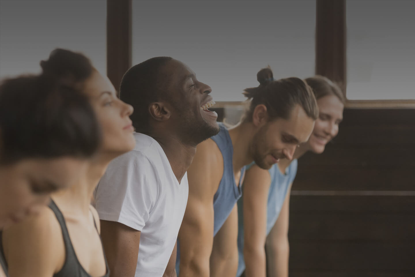 A group of individuals practicing yoga together in a class, include the wellbridge way in South Denver