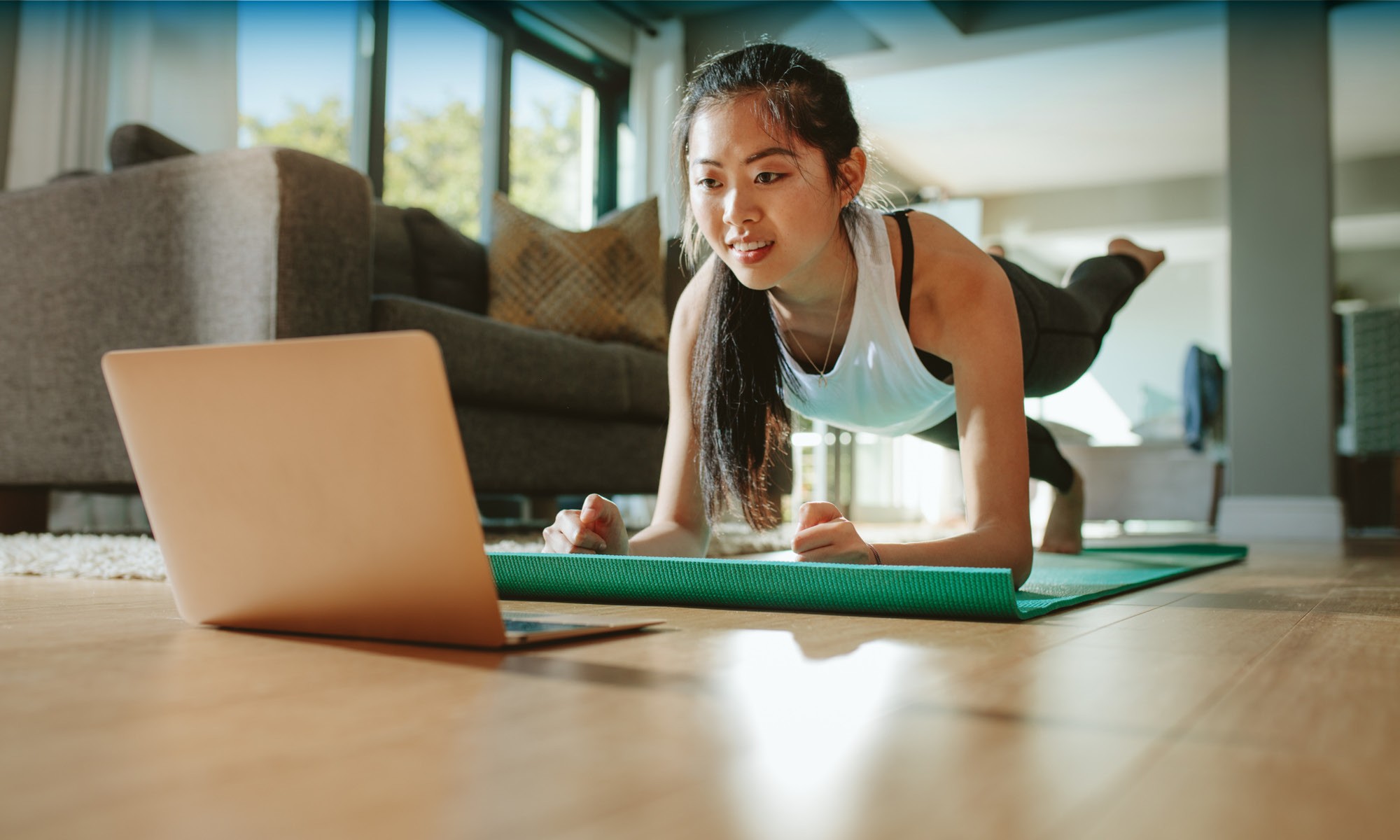 a girl excising while watching videos in laptop at Greenwood Village, CO