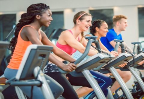Indoor cycling studio with bikes lined up in rows at Wellbridge 