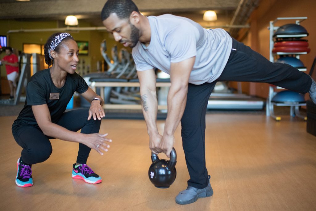 A personal trainer guides to a man in a South Denver
