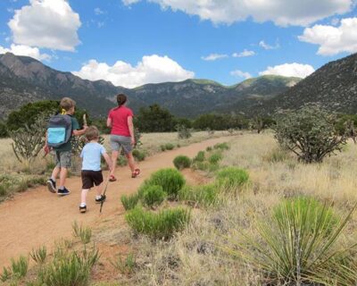 A family walking together on a dirt path while trekking in Albuquerque, NM