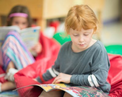 Girl Reading and Learning During Daycare | Colorado Athletic Club - Monaco