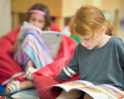 Girl Reading a Book at Colorado Athletic Club - Monaco's Daycare