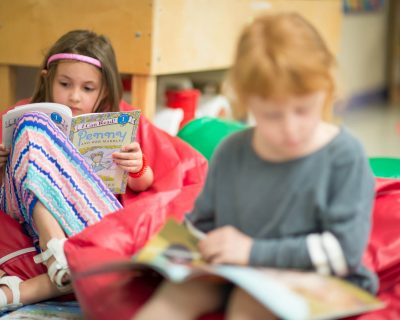 Young Girl Reading | Childcare at Colorado Athletic Club - Monaco