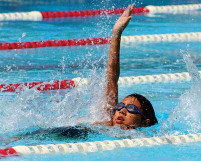 A boy splashing in a pool, surrounded by the warm sun in Albuquerque, NM