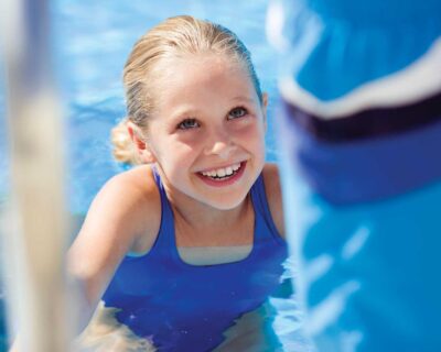 A Girl on a ladder of a swimming pool at Wellbridge Athletic Club