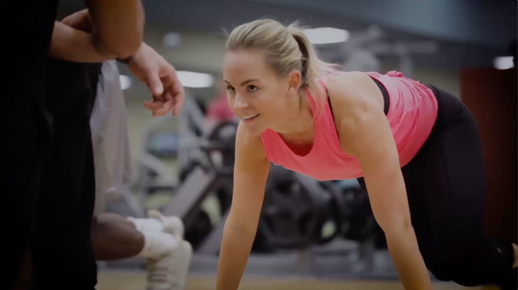 A woman engaged in push-ups at the gym, demonstrating her workout routine in South Denver  