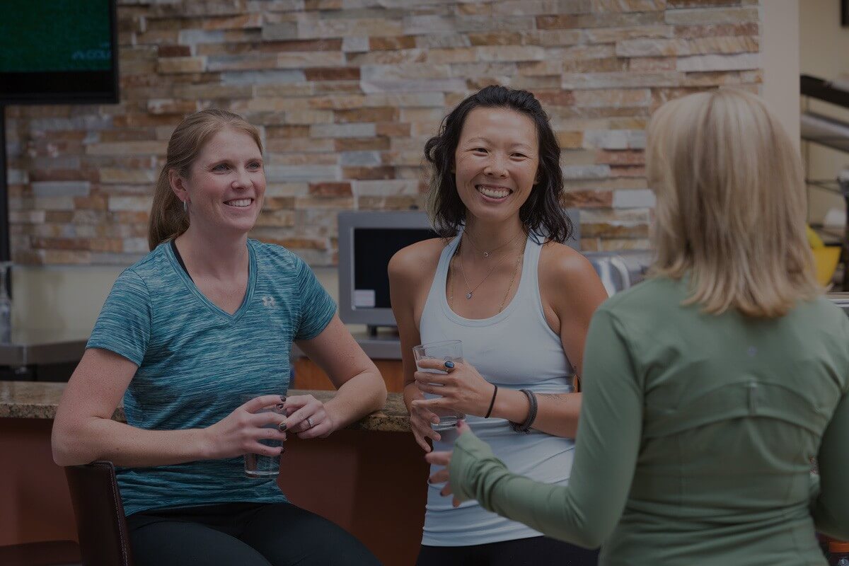 Three women chatting after a workout at the fitness center.