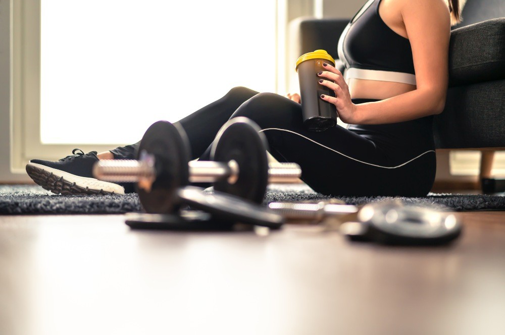 Woman taking creatine supplement before her workout.