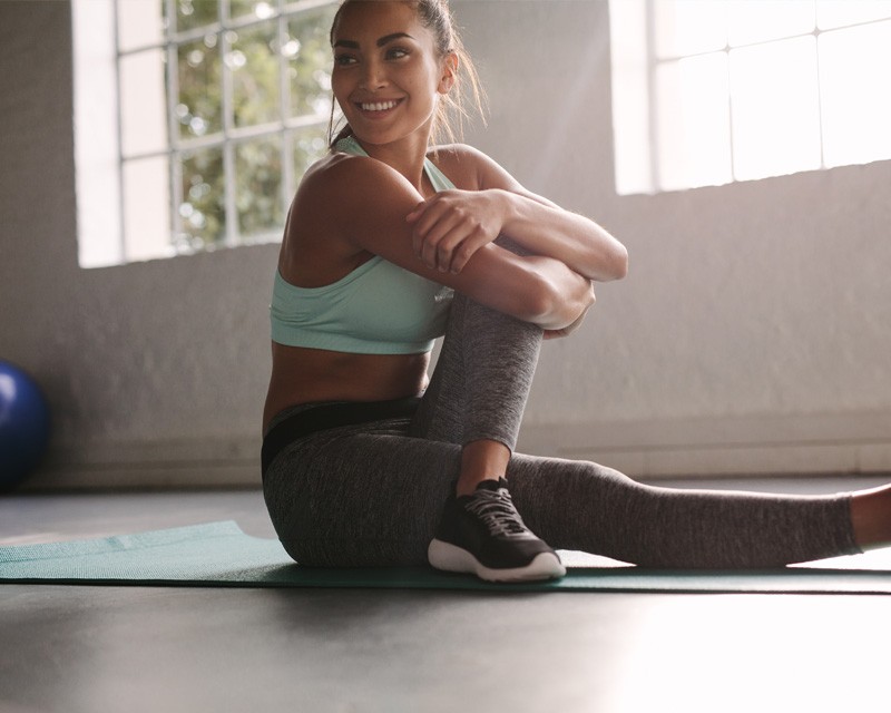A woman doing stretching on a yoga mat